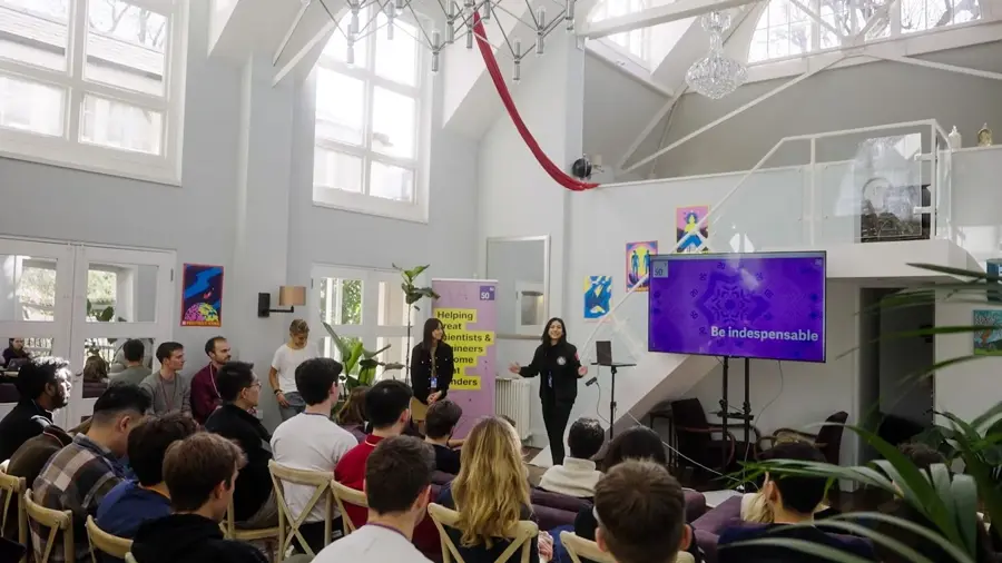 A group of people watching a talk at the 5050 Cohort 1 kick-off event