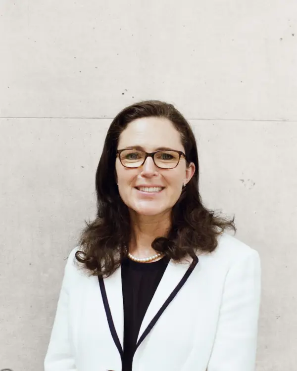 Headshot of Antonia Jenkinson standing in front of a white wall