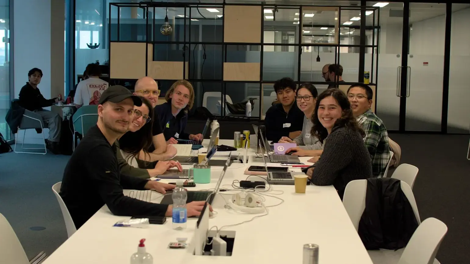 Group of people taking part in ARIA's Innovator Circles sitting at a desk smiling at the camera
