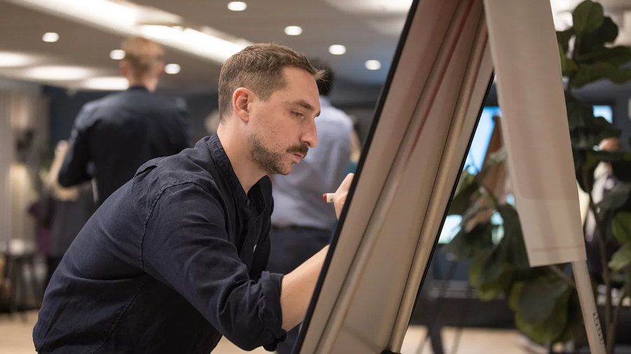 A photo of Jacques writing on a white board.