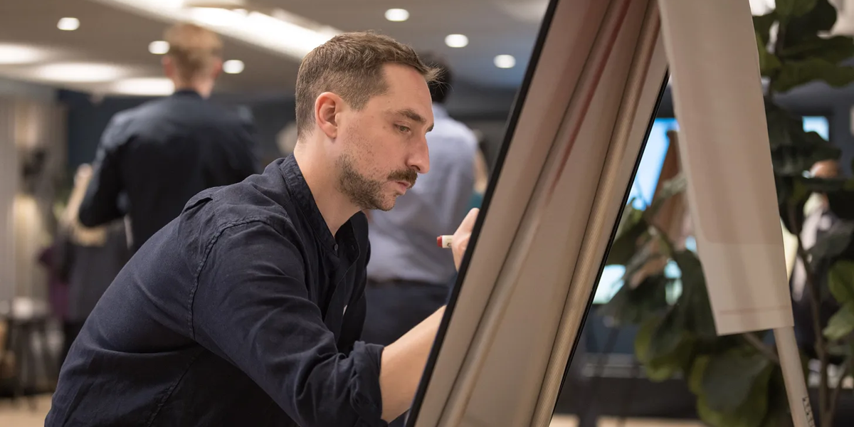 A photo of Jacques writing on a white board.