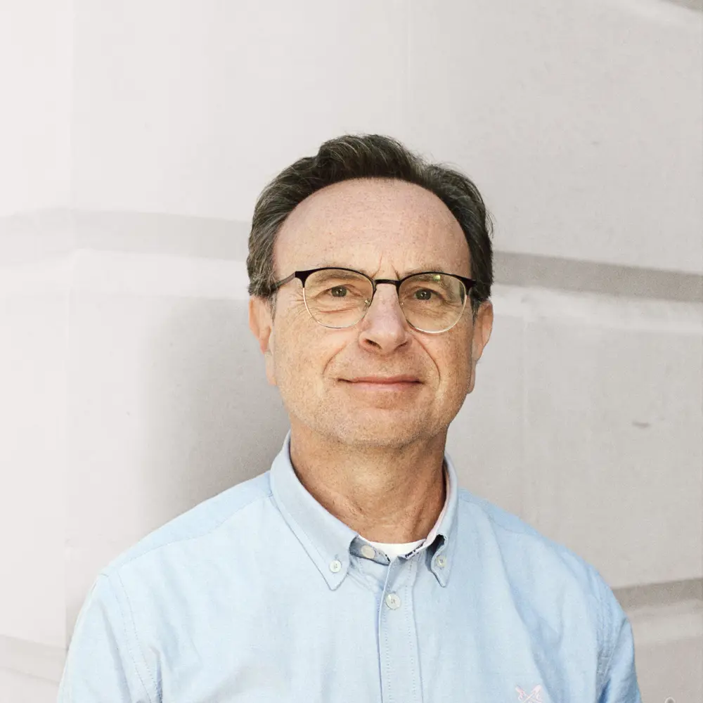 A photo of Paolo Toccaceli smiling in front of a white wall.