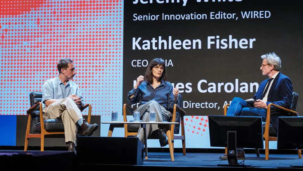 Jacques Carolan and Kathleen Fisher sitting on stage in discussion with Jeremy White from Wired Health