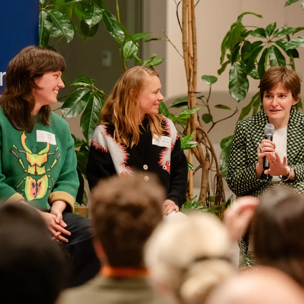 Kaja Wasik, Tosca Tindall, and Molly Blank in conversation on stage at an event.