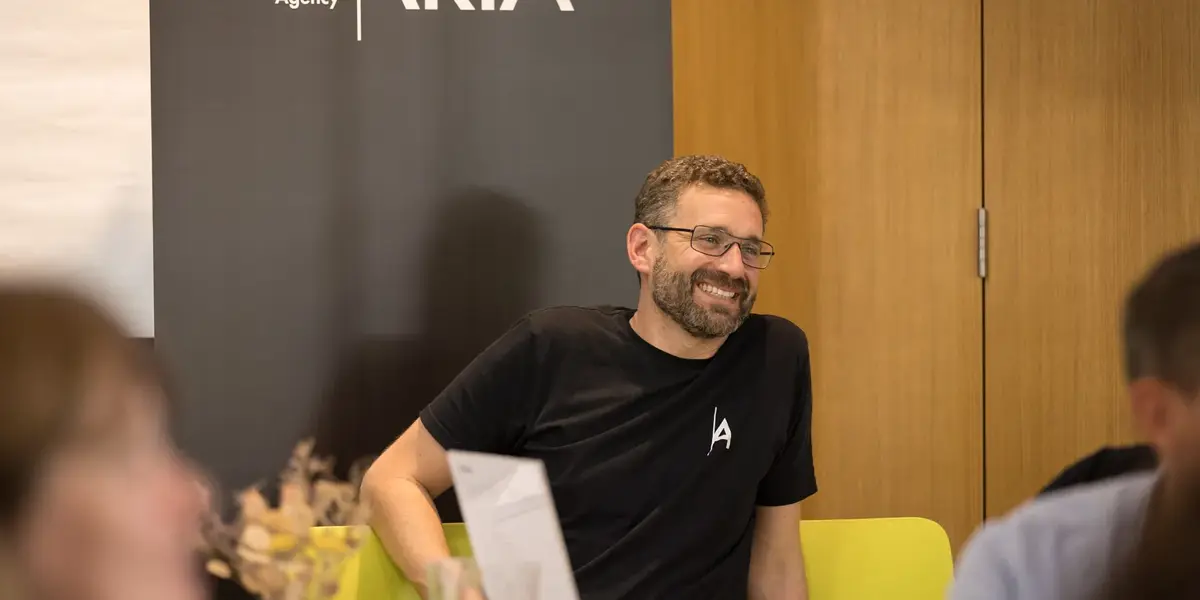 A man sitting and smiling at a table during a workshop