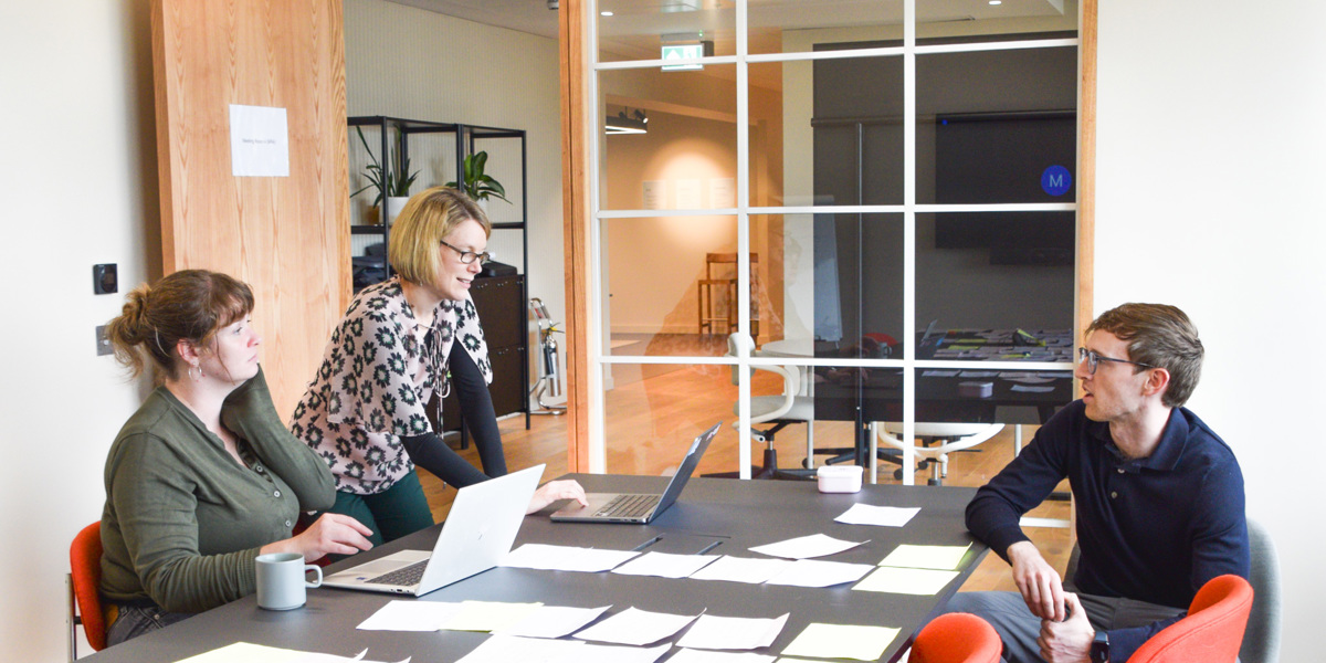 Programme Directors Sarah and Gemma working at a desk with their programme specialist