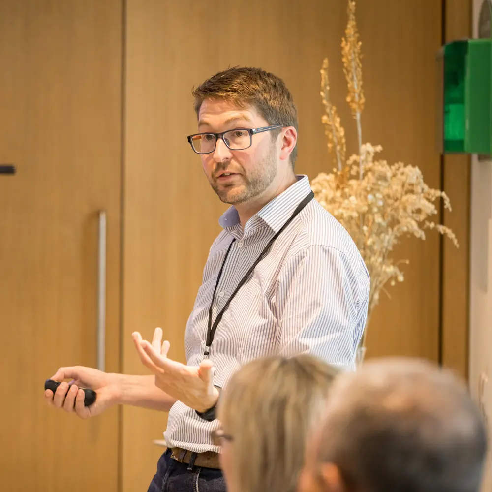 A photo of Mark Symes presenting at an event.