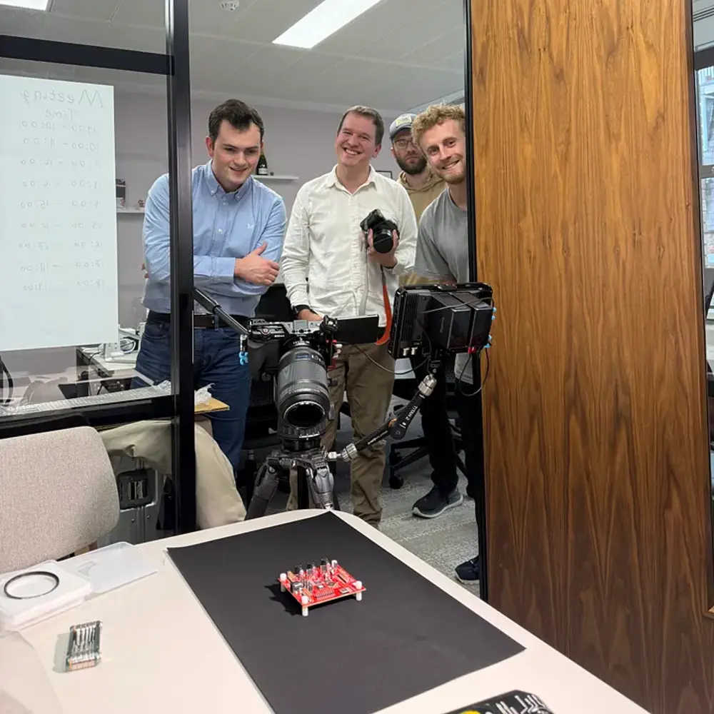 The Normal Computing team doing a photoshoot of their thermodynamic computing chip.